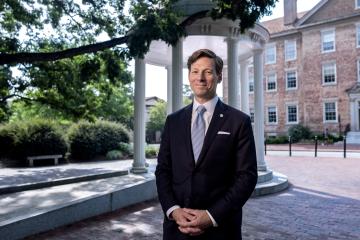Chancellor Lee H. Roberts stands in front of the Old Well