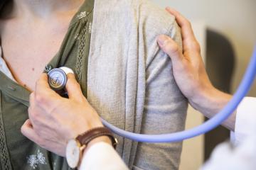 Doctor holding stethoscope up to patient's chest