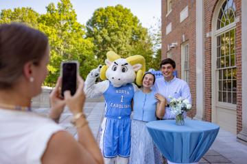 New students pose with Rameses at a new students event 