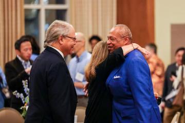 Members of ACRED greet each other at a meeting