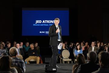 Jed Atkins speaks on stage at a SCiLL event