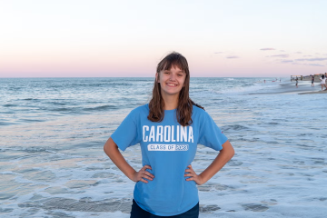 Izzie Estes smiles for a photo on the beach. 
