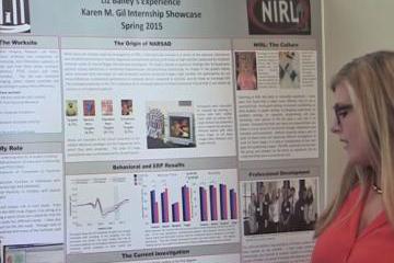 Liz Bailey points to a poster presentation. 