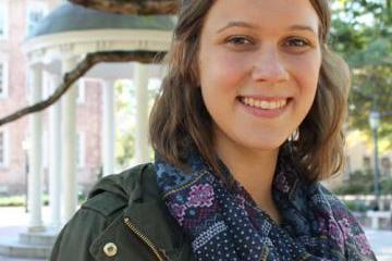 Sarah Jean Phipps smiles in front of the Old Well. 