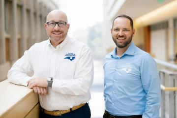 Dr. Michael Kretchmer and Dr. Michael Stella stand in a brightly lit atrium smiling.