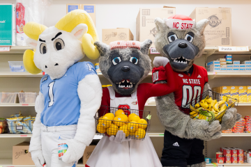 Ramses, Ms. Wuf and Mr. Wuf pose at a food pantry.