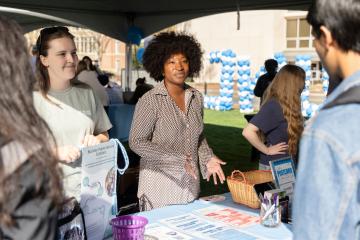 Carolina staff talk to visitors at an event near the Bell Tower