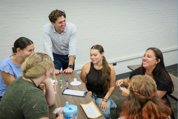 An instructor with a group of students in a classroom.