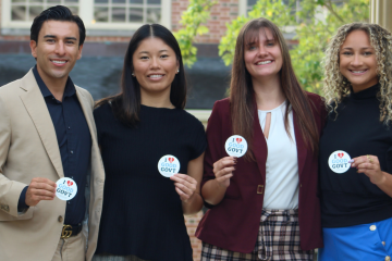 four people hold stickers that say "I love good government."