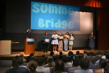 Students accept certificates on stage.