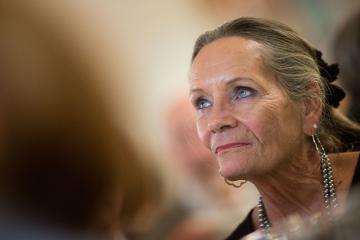 A portrait of the late Joan Gillings. Joan is leaning into the frame from the left and looking into the distance.