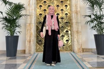 Mina Bayraktar stands in front of the doors of Grand National Assembly of Turkey.