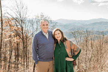 Dwight and Moira Jacobs smiling together in front of the mountains