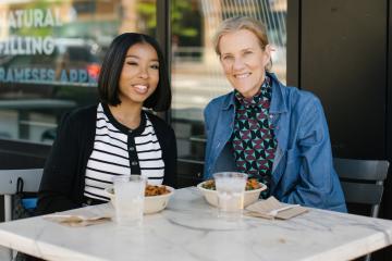 Grace Brown and Sunny Burrows seated at an outdoor table.