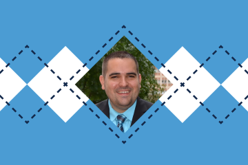 Portrait of person wearing suit and tie against a blue and white argyle backdrop.