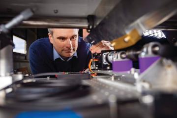Nicholas Law bending down looking into a piece of equipment