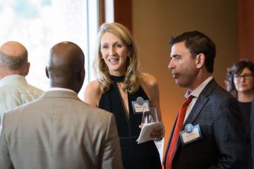 2 members of the Carolina Parents Leadership Society greet another event attendee