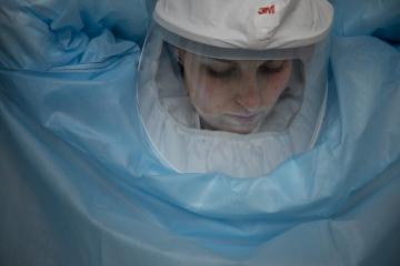 Researcher putting on a hazmat suit.