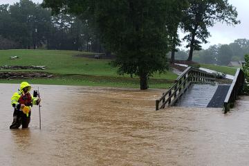 Man taking measurements in flood waters.