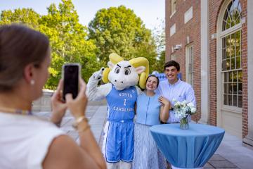 New students pose with Rameses at a new students event 