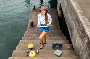 Savannah Ryburn on a pier conducting research.