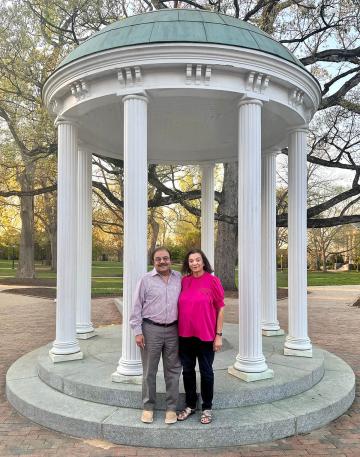 Tilak and Aruna Shah standing in front of the Old Well