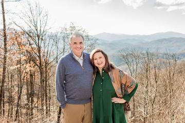 Class of 1987 alumni Dwight and Moira Jacobs standing in front of a mountainous background.