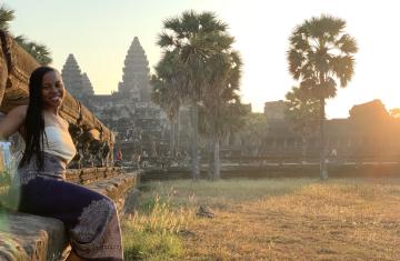 Taylor Doggett smiles in front of the Angkor Wat temple." Third image needs relevant alt text,