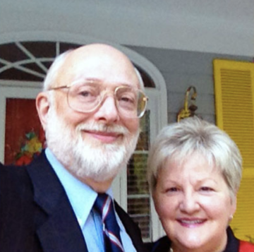 Carl and Susan Baumann smile on a front porch.