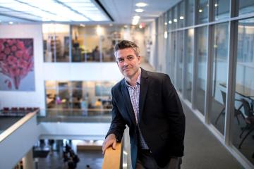 Morgan Pitelka, Bernard L. Herman Distinguished Professor in the UNC College of Arts and Sciences, leaning against a railing in an atrium