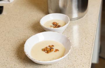 Two bowls of celeriac soup on a table.