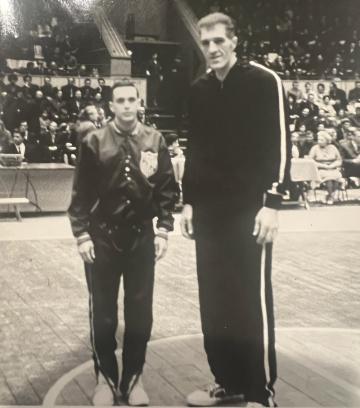 Larry Brown standing on a basketball court with USSR player Janis Krumins