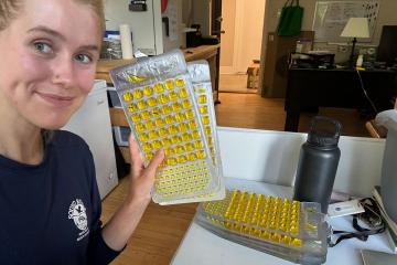 A selfie of Eloise MacLean holding water samples