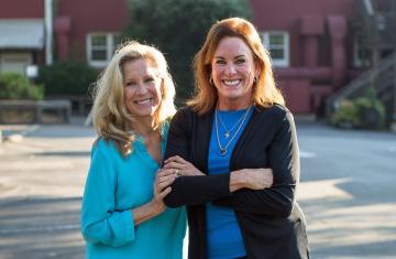 Shelley Belk and Van Eure smiling in front of the Angus Barn restaurant.