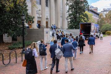Young Alumni Leadership Council members walking up the steps into Wilson Library from Polk Place.