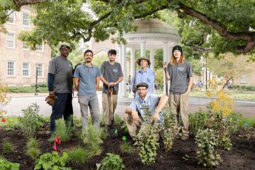 University Landscape Architect Dan Widis standing with five members of the groundskeeping team at UNC-Chapel Hill in front of the Old Well.