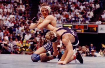 UNC wrestler T.J. Jaworsky holding an opponent by the leg during a match.