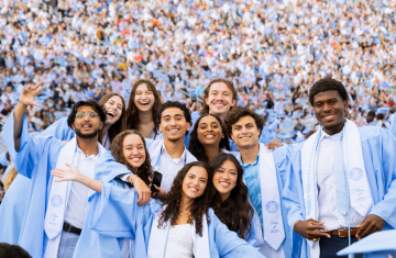 A group of Carolina graduates posing for a picture at Kenan Stadium.