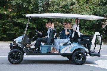 Chancellor Lee H. Roberts travels in a golf cart with his wife and three members of his staff
