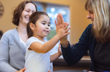 Child high fives an adult