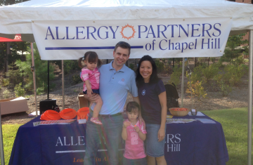 Dave Fitzhugh and family in front of "Allergy Partners of Chapel Hill" booth