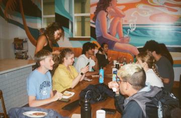 Students converse around a communal table