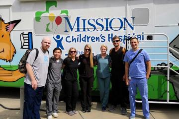 MAHEC's Rural Oral Health Scholars pose in front of a Mission Children's Hospital bus.
