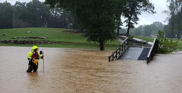 Man taking measurements in flood waters.