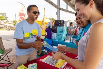 People exchange pleasantries at an outdoor festival.