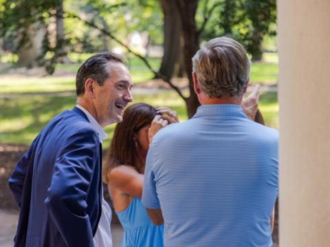 Man smiles and talks to others on the steps