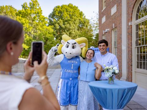 New students pose with Rameses at a new students event 