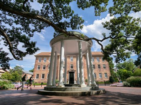 Students walking by the Old Well with South Building in the background
