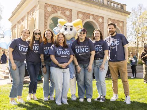 Carolina Annual Giving team members stand in front of the Bell Tower wearing GiveUNC t-shirts