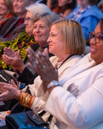 Guests clap in the audience of an event.